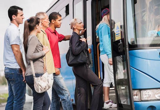 Large group of people boarding a bus.